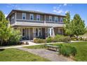 Attractive townhome with a welcoming covered porch, neat landscaping, and a shared green space at 11033 E 28Th Pl, Denver, CO 80238