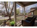 Inviting front porch featuring wicker furniture, offering a cozy outdoor seating area at 1169 Thornbury Pl, Highlands Ranch, CO 80129