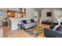 Inviting living room features hardwood floors, comfortable seating, with an open view to the kitchen and staircase at 3785 E 134Th Ct, Thornton, CO 80241