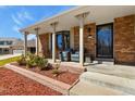 Inviting front porch with brick accents, stylish seating, and a well-manicured garden at 3785 E 134Th Ct, Thornton, CO 80241