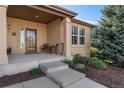 Inviting front porch featuring a seating area and a decorative glass front door at 5662 W Peakview Pl, Littleton, CO 80123