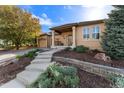 Beautiful home showcasing a meticulously landscaped front yard with rock accents and a cozy front porch at 5662 W Peakview Pl, Littleton, CO 80123