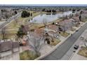 Aerial view of homes near a tranquil lake with walking trails and mature landscaping at 18292 E Caspian Pl, Aurora, CO 80013