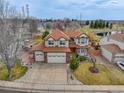 Well-maintained two-story home featuring a three-car garage, brick accents, and mature trees at 18292 E Caspian Pl, Aurora, CO 80013