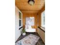 Cozy porch with wood paneled walls, stylish rug, and ample natural light at 1453 Rosemary St, Denver, CO 80220