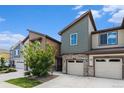 Townhome exterior featuring a stone base, neutral siding, and a well-kept lawn under a clear blue sky at 9757 Ash Ln, Thornton, CO 80229