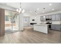 Modern kitchen with stainless appliances, a center island, and sliding door access to outdoor space at 9757 Ash Ln, Thornton, CO 80229