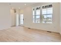 Bright living room showcasing beautiful hardwood floors and large windows that fill the space with natural light at 8895 San Antonio St, Littleton, CO 80125