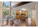 Open kitchen and dining area with wood floors, stainless appliances, and large windows offering natural light at 27891 Columbine Rd, Evergreen, CO 80439