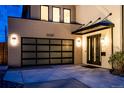 Charming home exterior featuring a modern garage door, a covered entry, and elegant outdoor lighting at 3087 S Dexter Way, Denver, CO 80222