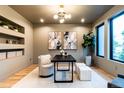 Stylish home office featuring a modern light fixture, a sleek desk, and large windows at 3087 S Dexter Way, Denver, CO 80222