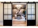Home office with large sliding doors, hardwood floors, stylish decor, and ample natural light at 3087 S Dexter Way, Denver, CO 80222