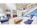 Bright living room boasts soaring ceilings, a cozy fireplace, and a stylish staircase leading to the upper level at 5932 Eldora St, Golden, CO 80403