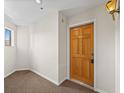 Hallway with light brown carpet and a wooden door with a brass knocker at 31819 Rocky Village Dr # 301, Evergreen, CO 80439