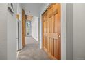 Hallway with wood-look closet doors and a view into the main living space at 31819 Rocky Village Dr # 301, Evergreen, CO 80439