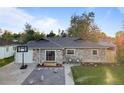 Charming single-story stone home featuring a well-manicured lawn and a basketball hoop in the driveway at 1085 Victor St, Aurora, CO 80011