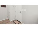 Neutral entryway featuring coat closet, key rack, and white front door with welcome mat at 13754 Ash Cir, Thornton, CO 80602