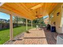 A covered outdoor patio with brick flooring, ceiling fans, and seating perfect for relaxation at 15122 Fillmore Way, Thornton, CO 80602