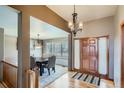 Inviting home entry featuring a wood door, chandelier, and hardwood floors at 15901 W 66Th Pl, Arvada, CO 80007