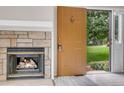 Living room with fireplace and an open front door leading to a green yard at 8406 Everett Way # C, Arvada, CO 80005
