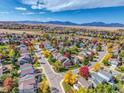 Expansive aerial view of a neighborhood nestled among colorful fall foliage and distant mountains at 1462 Hyacinth Way, Superior, CO 80027