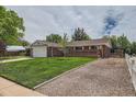 A single-story brick home with a lush green lawn, long driveway, and mature trees offering shade and curb appeal at 13472 E Dakota Ave, Aurora, CO 80012