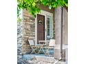 Cozy front porch with a table and chairs, stone accents, and a welcoming front door at 10482 Billings St, Commerce City, CO 80022