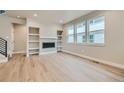 Bright living room features hardwood floors, built-in shelving, and a modern fireplace at 2751 E 102Nd Pl, Thornton, CO 80229