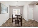 Bright dining area featuring a modern light fixture, window, and dark wood table and chairs at 481 Vista Blvd, Brighton, CO 80603