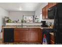 Functional kitchen featuring wooden cabinets, black appliances, and a breakfast bar at 481 Vista Blvd, Brighton, CO 80603