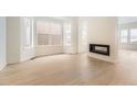 Bright living room featuring a modern fireplace and stylish hardwood floors at 3929 Treadway Pt, Castle Rock, CO 80108