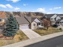 An aerial view of a well-maintained home featuring a stone facade, two-car garage, and a landscaped yard at 3966 Aspen Hollow Ct, Castle Rock, CO 80104