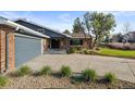 Home's front exterior shows brick finishes, a long driveway, and tidy landscaping at 10801 W 29Th Ave, Lakewood, CO 80215