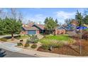 Landscaped front yard of this charming brick home with street sign in view at 10801 W 29Th Ave, Lakewood, CO 80215