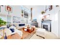 Bright and airy living room boasts soaring ceilings, fireplace, and stylish decor at 6051 E 160Th Pl, Brighton, CO 80602