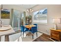 Bright dining area with large window, slider to patio, modern lighting, and comfortable blue chairs at 1530 Terry St, Longmont, CO 80501