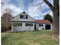 Charming home featuring a well-kept lawn, red roof, black shutters, and a one-car garage at 2725 S Monroe St, Denver, CO 80210