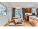 Dining area with modern lighting, wood table, and direct access to the kitchen and backyard at 4861 Curie Ct, Boulder, CO 80301