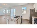 Gourmet kitchen featuring granite island with stainless steel sink and modern appliances at 13832 Honey Hush Trl, Parker, CO 80134