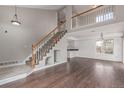 Bright living room featuring hardwood floors, a staircase, and access to the kitchen at 4152 Netherland St, Denver, CO 80249