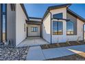 Modern home with covered front porch, large windows, and low-maintenance yard at 8648 Carneros Ct, Parker, CO 80138
