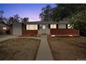 Charming single-story home with brick accents, a well-manicured lawn, and attached garage at 2251 Braun Dr, Golden, CO 80401