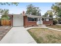 Charming single-story home with brick accents, a well-manicured lawn, and attached garage at 2251 Braun Dr, Golden, CO 80401