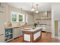 Farmhouse kitchen featuring a marble-top island, custom cabinets, butcher block countertops, and stainless steel appliances at 841 Niagara St, Denver, CO 80220