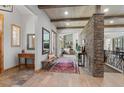 Elegant entryway featuring wood floors, brick accents, and a view into the living room with fireplace at 25350 Ridge Way, Golden, CO 80401
