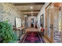 Inviting foyer with exposed wood beams, a brick wall, hardwood floors, and elegant decor at 25350 Ridge Way, Golden, CO 80401