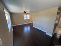 Spacious living room with dark hardwood floors, neutral paint, and natural light from multiple windows at 7021 Saulsbury St, Arvada, CO 80003