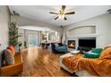 Spacious living room with hardwood floors, a fireplace, and an open floor plan to the dining area at 23662 E Alabama Dr, Aurora, CO 80018