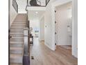 Bright foyer with wood floors, staircase, and a glimpse into the living room and adjacent bathroom at 2515 Clayton Cir, Superior, CO 80027