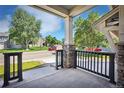 Inviting front porch with stone pillars, decorative railings, and a view of a tree-lined residential street at 2515 Clayton Cir, Superior, CO 80027